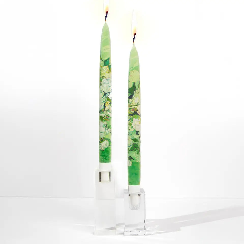Set of two decorative taper candles inspired by Van Gogh Still Life Vase with Pink Roses artwork featuring painterly green floral designs and handcrafted flat candle style.