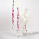Set of two decorative pink cherry blossom taper candles featuring delicate floral artwork and handcrafted flat candle design.