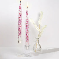 Set of two decorative pink cherry blossom taper candles featuring delicate floral artwork and handcrafted flat candle design.