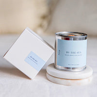Coastal soy candle with wood wick in reusable tin featuring sea salt and coconut fragrance