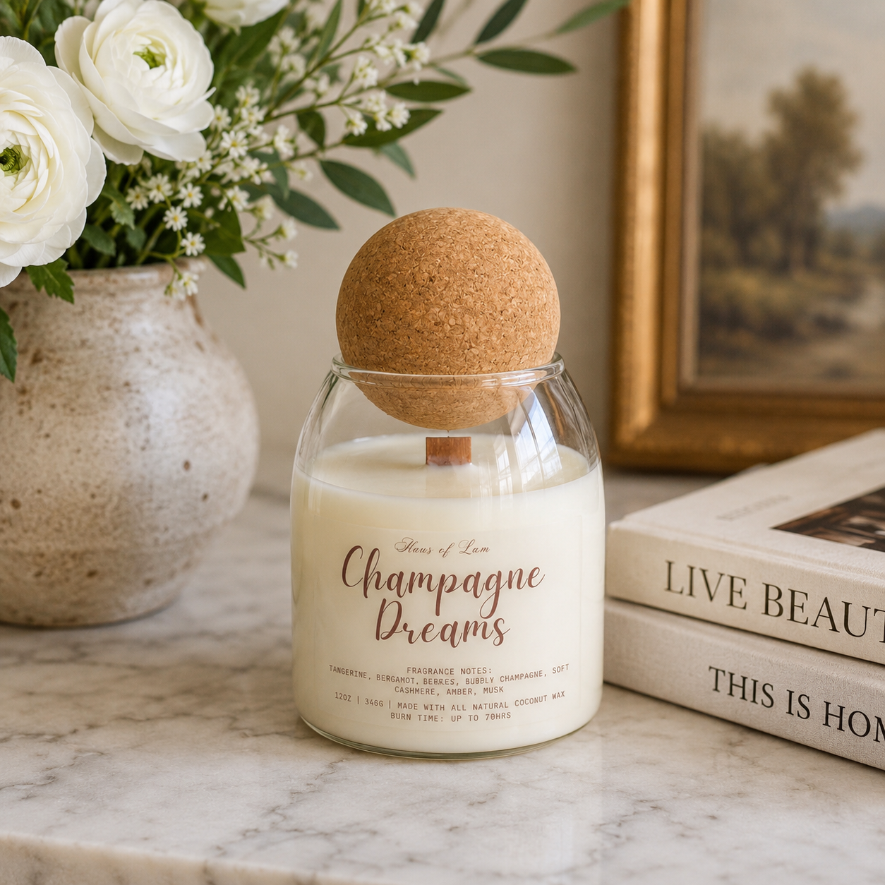 Luxury Champagne Dreams candle with cork lid in modern glass vessel, styled with soft florals and neutral decor for an elegant feminine home aesthetic.