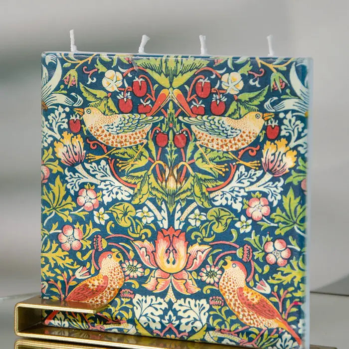 William Morris Strawberry Thief flat decorative candle featuring colorful birds and floral botanical artwork with brass display stand.