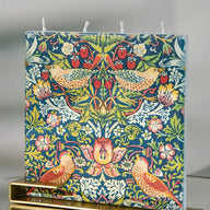 William Morris Strawberry Thief flat decorative candle featuring colorful birds and floral botanical artwork with brass display stand.
