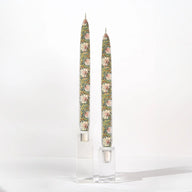 Set of two William Morris Pimpernel decorative taper candles featuring botanical floral artwork in soft sage green, blush, and cream tones.